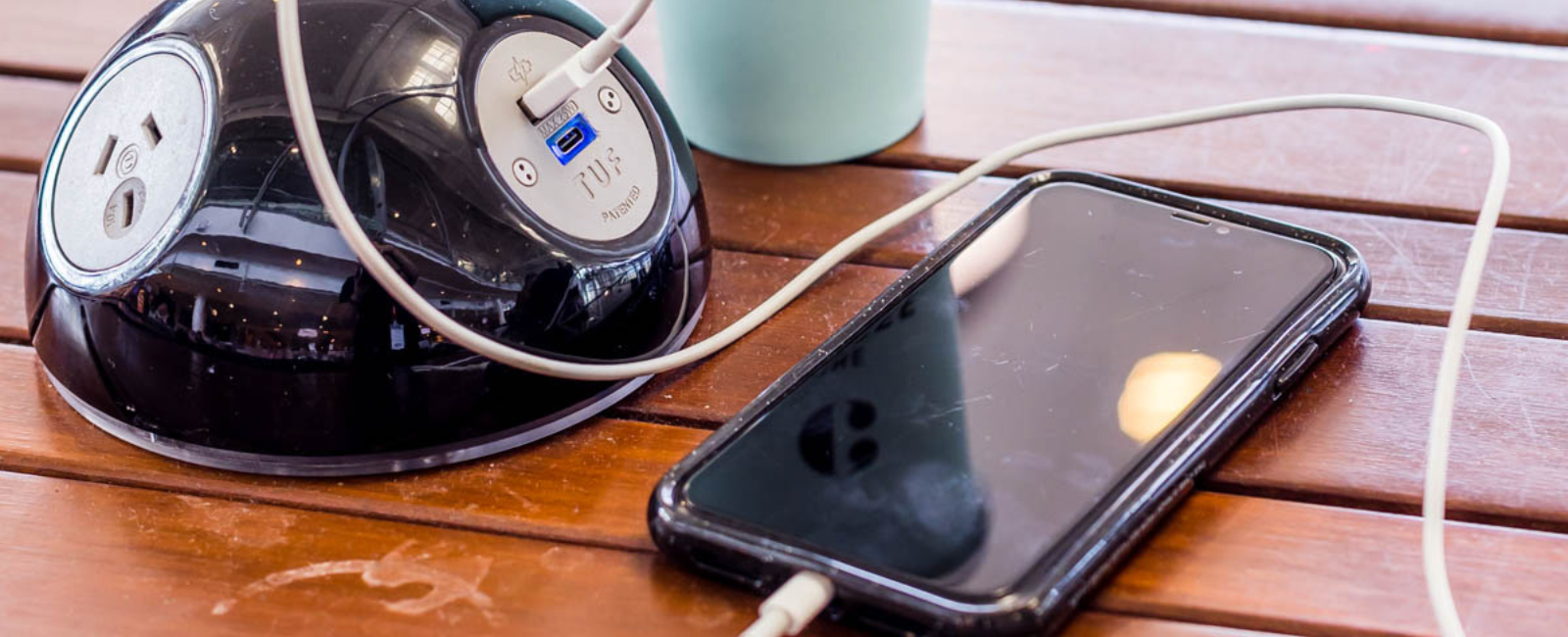 Phone plugged into a free charging station in the International Terminal